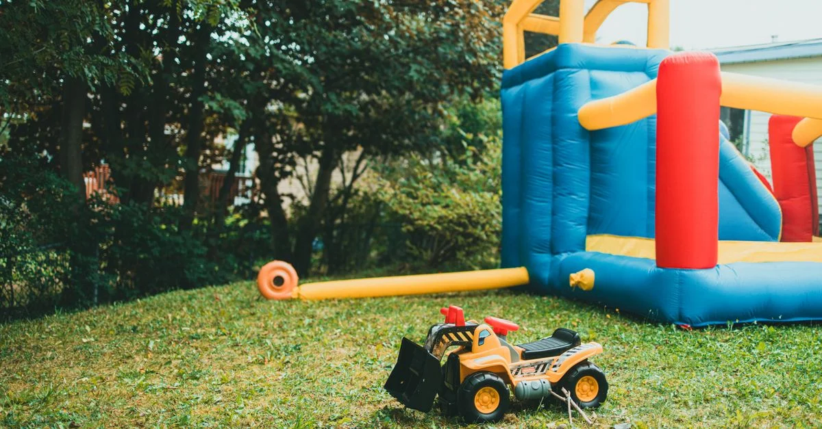 Diversión en el jardín con una estructura inflable y un camión de juguete perfecto para la recreación de los niños.