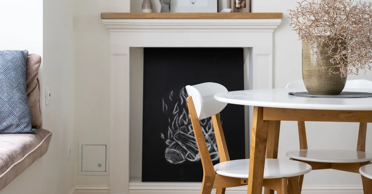 Une salle à manger élégante avec du mobilier en bois et une cheminée artistique. Atmosphère chaleureuse et accueillante.